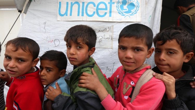 Displaced Iraqi children queue up outside a school funded by UNICEF