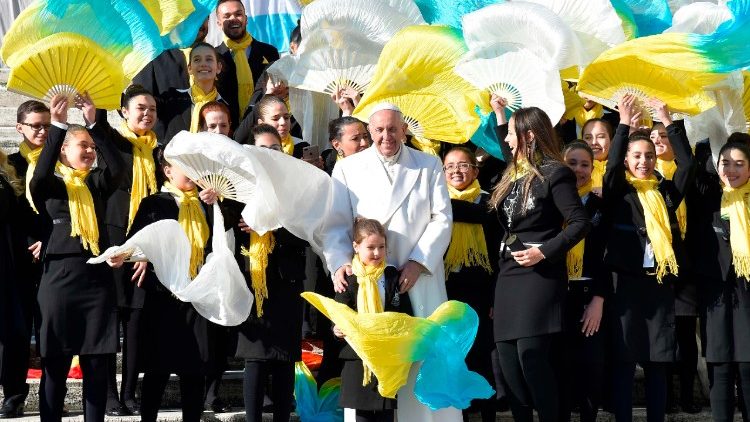 Pope Francis poses with a group of faithful at his Wednesday general audience.