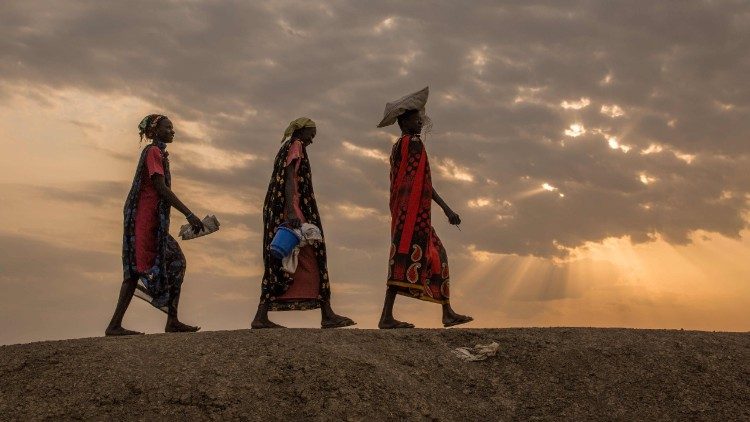 Internally displaced women walk to a food distribution centre in Bentiu, South Sudan