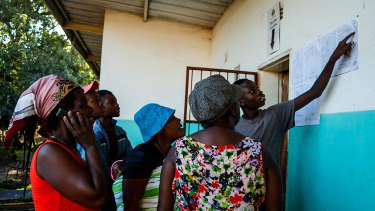 People gather to look at ballot count results posted outside a polling station 