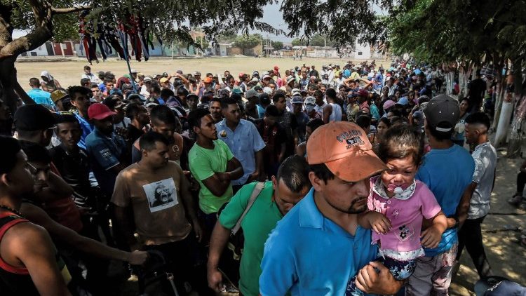 People fleeing the humanitarian crisis in Venezuela wait for food assistance on the Colombian border