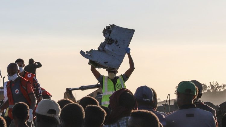 Workers search debris at the site of an Ethiopian airlines crash