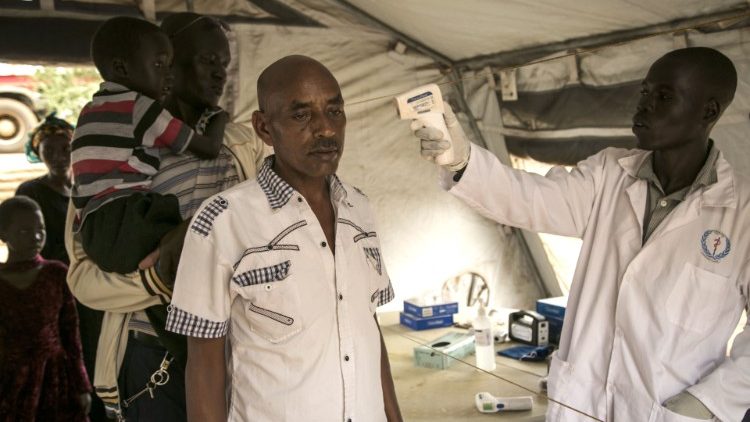 Health worker checks a traveler's temperature at South Sudan's border with Uganda