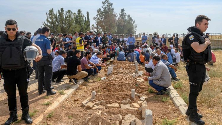People take part in a funeral for a Kurdish baby killed by artillery fire in Syria