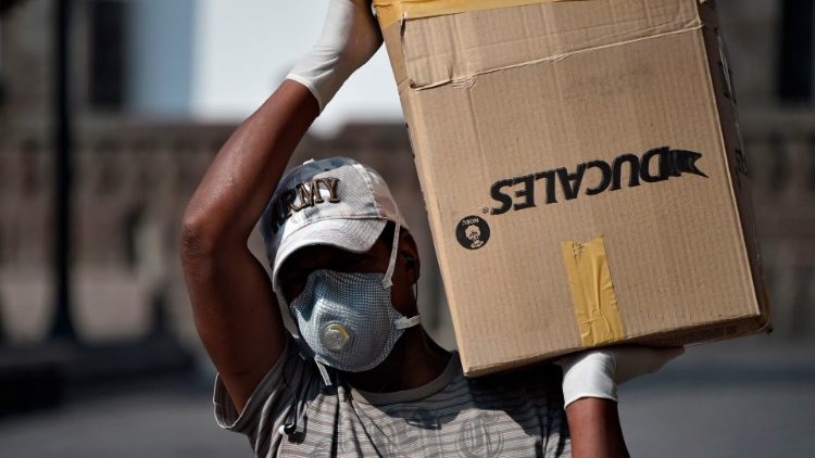 Equatoriano com máscara de proteção carrega provisões no Centro Histórico de Quito