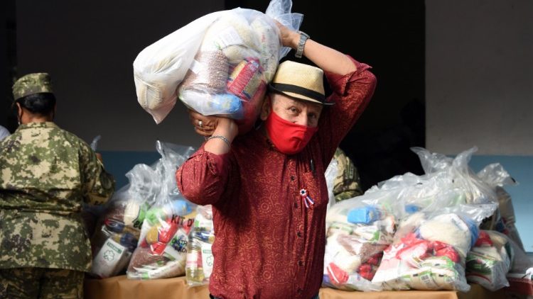 Un homme porte des vivres distribués par l'armée dans un quartier pauvre d'Asuncion, la capitale du Paraguay.