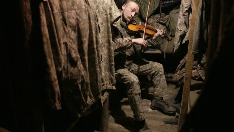 A Ukrainian serviceman plays the violin on the frontlines in Eastern Ukraine, 22 December