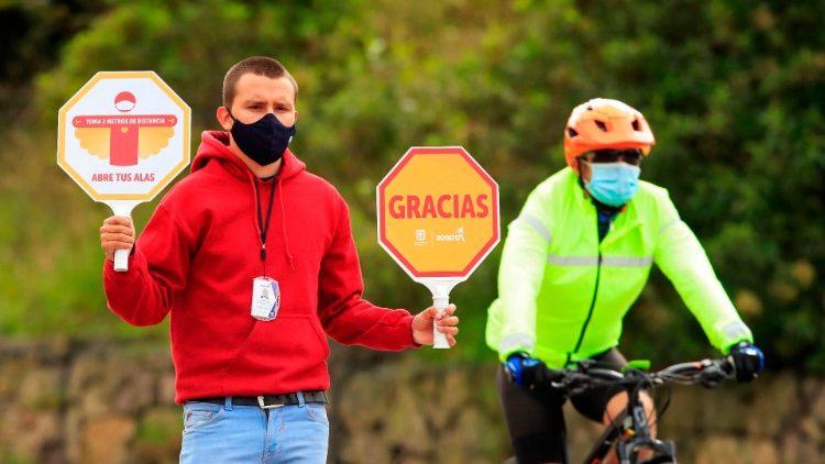Funcionário do governo segura uma placa pedindo às pessoas que mantenham o distanciamento social