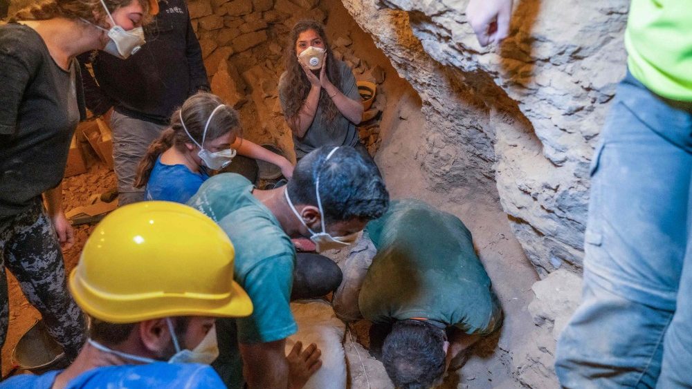 Trabalhadores e arqueologistas analisam material encontrado na caverna