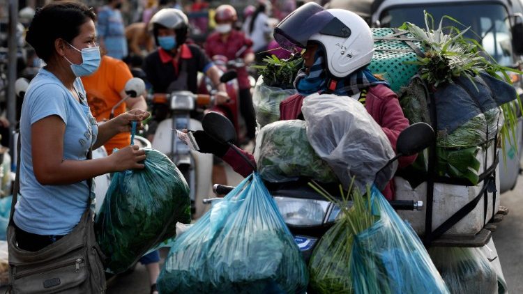 Cambojana compra vegetais na rua enquanto os mercados permaneciam fechados em meio a restrições introduzidas para tentar impedir um aumento de casos do coronavírus Covid-19 em Phnom Penh. (Foto de TANG CHHIN Sothy / AFP)
