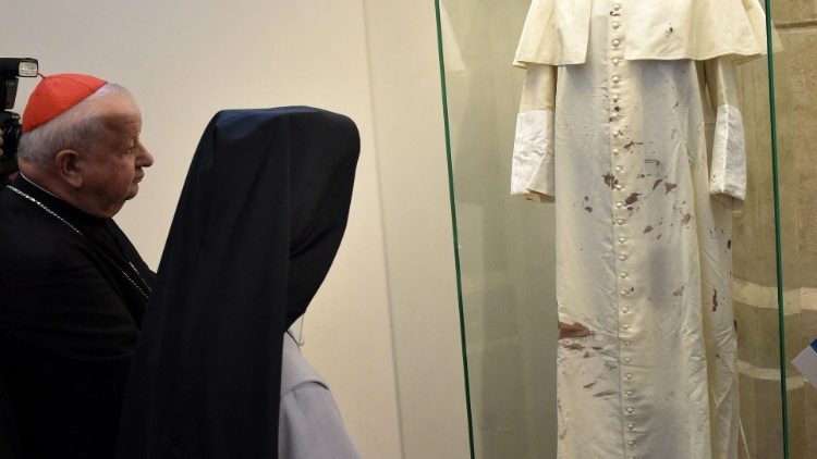 El cardenal Stanislaw Dziwisz ante las vestiduras blancas de San Juan Pablo II manchadas de sangre.