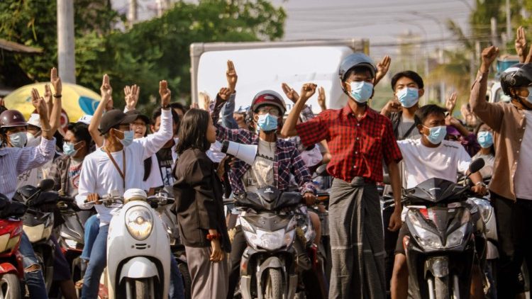 Manifestantes em Mandalay fazem a saudação de três dedos, um símbolo da resistência, durante uma manifestação contra o golpe militar.