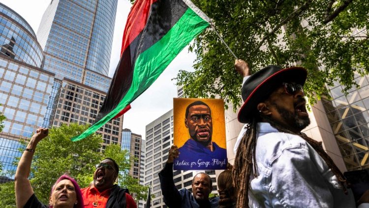 Manifestanti fuori dal tribunale di Minneapolis con i ritratti di George Floyd 