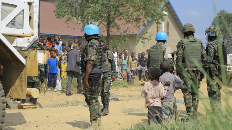 Peacekeeping forces stand guard outside the Butsili Catholic Church in Beni following the bomb explosion on Sunday