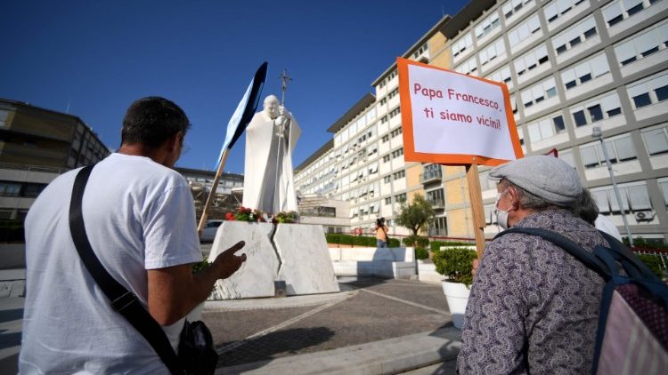 Ubodzy modlą się za Franciszka przed pomnikiem św. Jana Pawła II