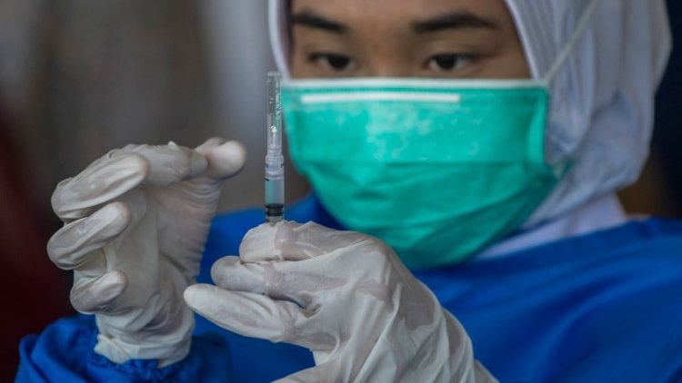 Una dottoressa indonesiana si appresta a somministrare una dose di vaccino Covid-19 (Juni Kriswanto / Afp)