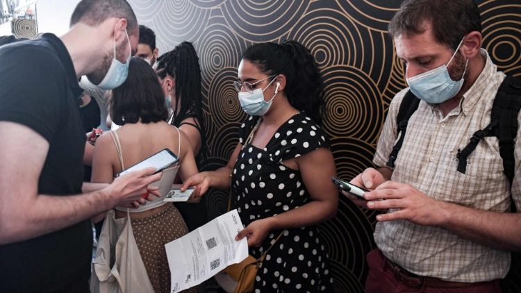 Cittadini francesi esibiscono il Green Pass a Parigi prima di entrare al cinema (Alain Jocard / Afp)