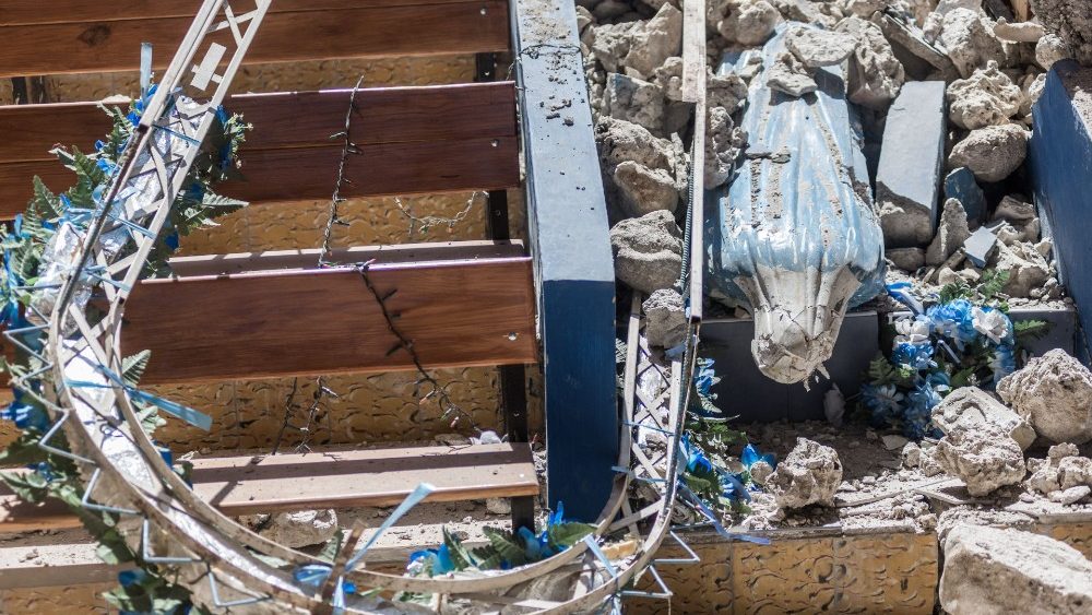 Uma estátua da virgem da igreja "Sacro coeur des Cayes" é vista sob os escombros em Les Cayes em 15 de agosto de 2021. (Photo LOUISSAINT JR / AFP)