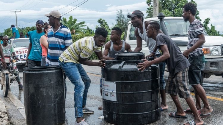 Personas reunidas cerca de contenedores de agua tras el terremoto en Camp-Perrin, Haití, el 16 de agosto de 2021. 