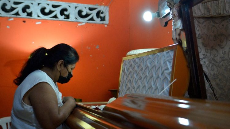  El familiar de uno de los 119 presos muertos en un estallido de violencia de pandillas en una prisión, llora junto a su ataúd. 