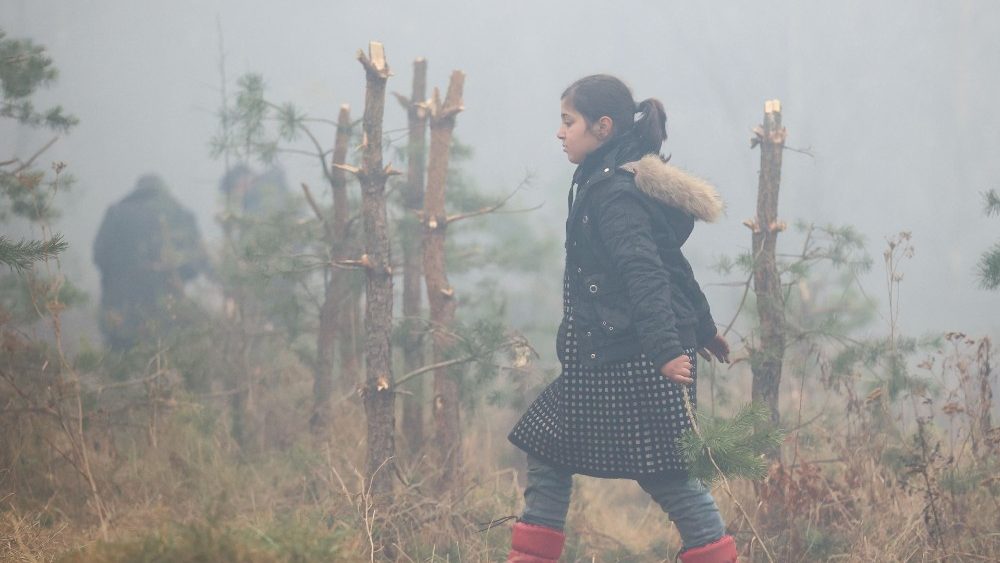 Jovem migrante caminha em bosque com neblina em Grodno, fronteira entre Belarus e Pol°onia )Foto_ Leonid Shcheglglov/BELTA/AFP)