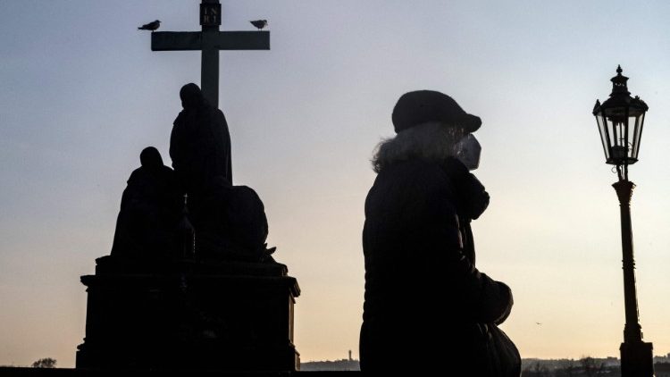 Eine ältere Frau mit Gesichtsmaske geht am 19. Januar über die Karlsbrücke in Prag.