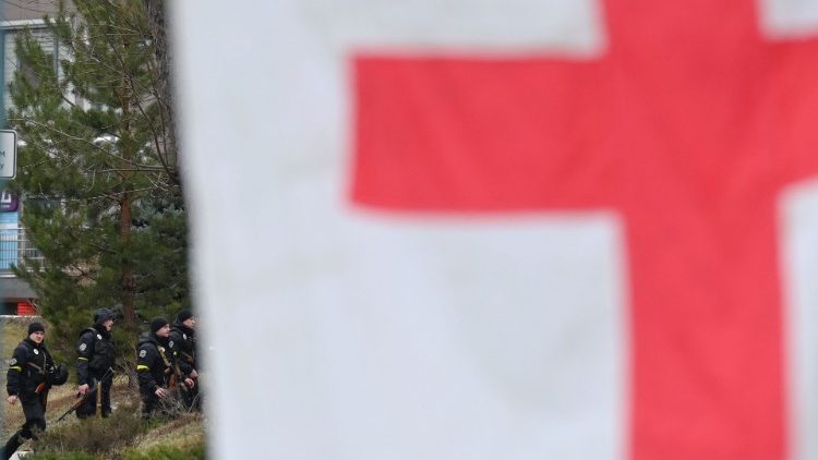 Militares da equipe especial da polícia armada caminham do lado de fora do hospital infantil central de Kiev, durante a evacuação de pacientes para a Polônia e a Alemanha. (Foto de Sergei SUPINSKY/AFP)