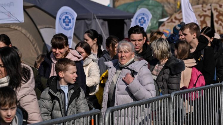 Profughi ucraini varcano il confine con la Polonia (foto Afp)
