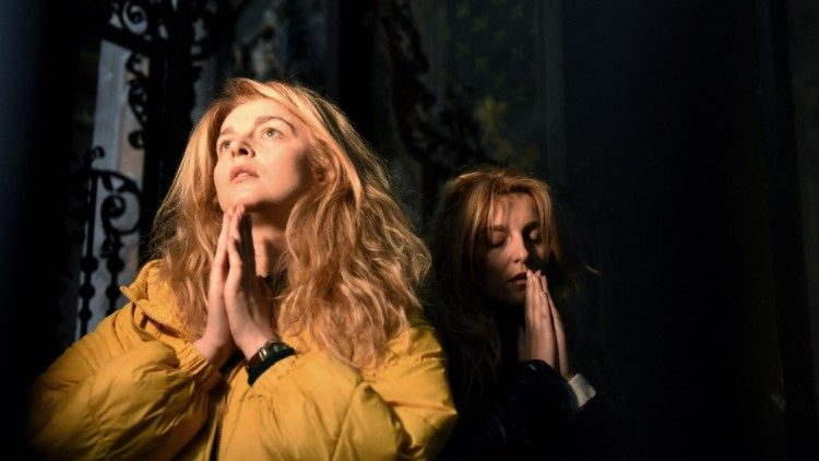 Ucraniana em oração na Catedral católica em Lviv (Photo by Yuriy Dyachysshyn/AFP)