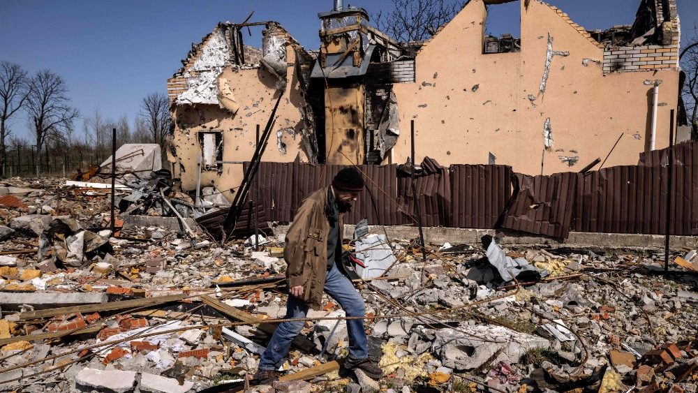 Um homem caminha perto de uma casa destruída na vila de Bohdanivka, a nordeste de Kiev, em 14 de abril de 2022, em meio à invasão da Rússia lançada na Ucrânia. (Foto: FADEL SENNA/AFP)