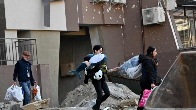 Kiev: un palazzo danneggiato dai bombardamenti e la gente è in fuga