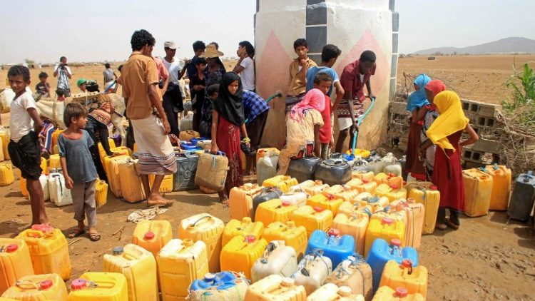 Yemenis fill their jerrycans with water at a camp for IDPs in the northern Haijah province