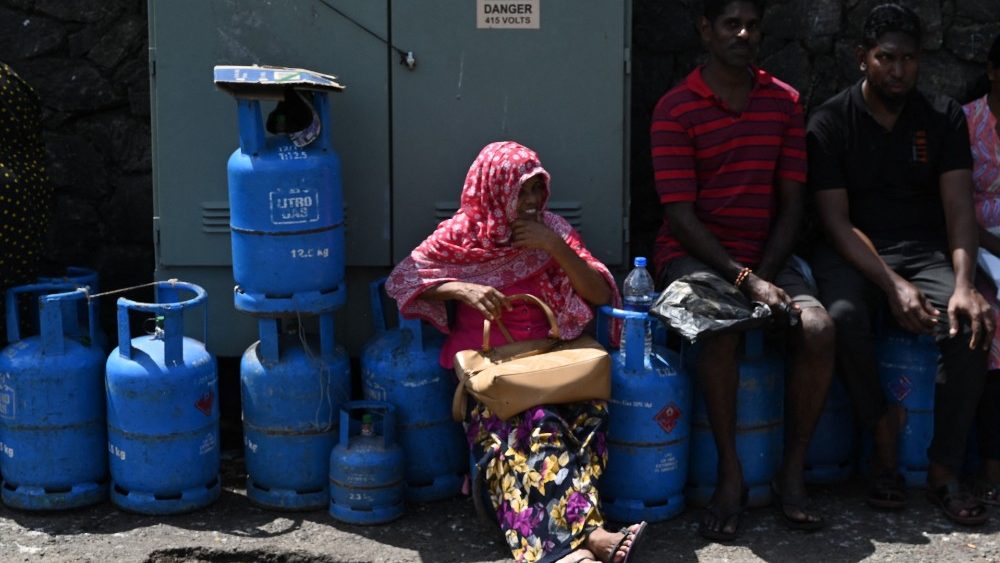 Pessoas esperam em fila para coletar botijões de Gás Liquefeito de Petróleo (GLP) em um ponto de distribuição em Colombo em 12 de julho de 2022. (Foto de Arun SANKAR/AFP)
