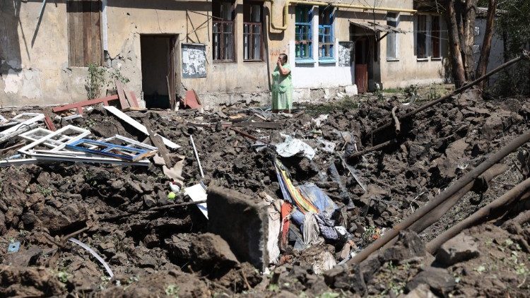 Uma mulher está em frente a sua casa destruída após um ataque aéreo russo na cidade de Toretske, na região de Donetsk, em 17 de julho de 2022, em meio à invasão militar russa da Ucrânia. (Foto de Anatolii Stepanov/AFP)