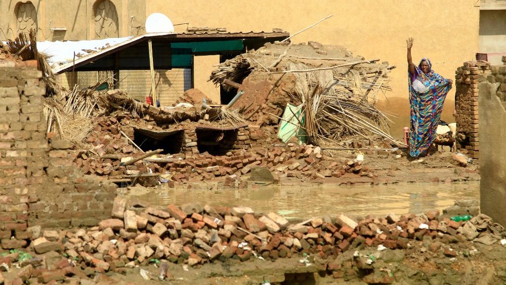 Uma mulher sudanesa acena em uma rua inundada na cidade de Iboud, 250 km ao sul da capital Cartum, em 22 de agosto de 2022. (Foto de Ebrahim Hamid / AFP)