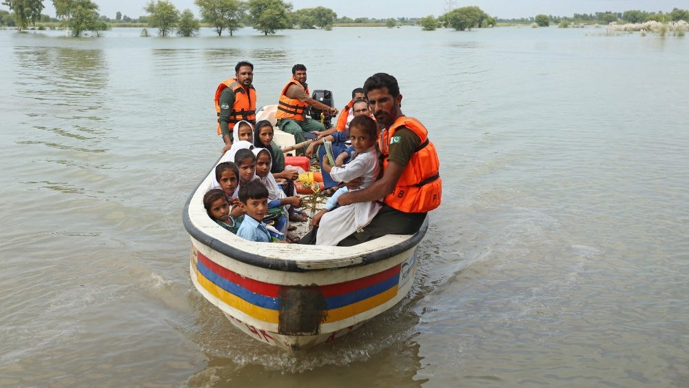 Equipes de resgate usam um barco para levar crianças de volta para casa depois da escola em uma área atingida por inundações após fortes chuvas de monção no distrito de Dera Ghazi Khan, na província de Punjab, em 29 de agosto de 2022. de acordo com dados divulgados em 29 de agosto pela Autoridade Nacional de Gestão de Desastres do país. (Foto de Shahid Saeed MIRZA/AFP)