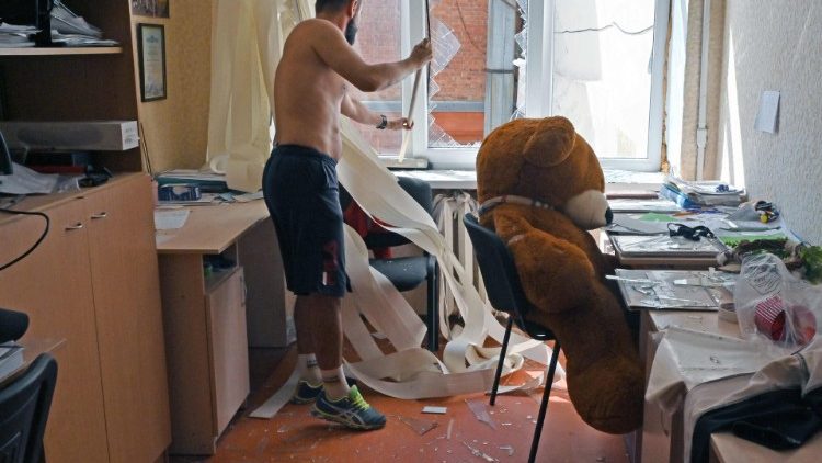 Um professor remove vidro quebrado em uma sala de uma escola pública após um ataque aéreo em Kharkiv em 27 de agosto de 2022, em meio à invasão russa da Ucrânia. (Foto de SERGEY BOBOK/AFP)