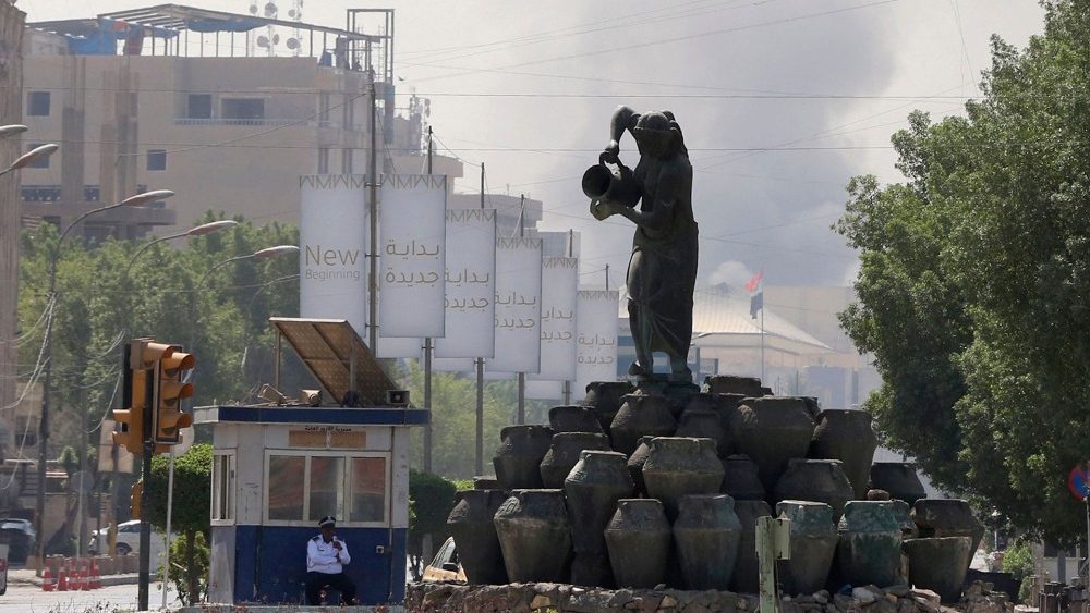 A fumaça sobe ao fundo na capital Bagdá durante um toque de recolher imposto pelo exército em 30 de agosto de 2022, um dia depois que 23 apoiadores do poderoso líder xiita Moqtada Sadr foram mortos a tiros durante os combates na Zona Verde de Bagdá. (Foto de Sabah ARAR/AFP)