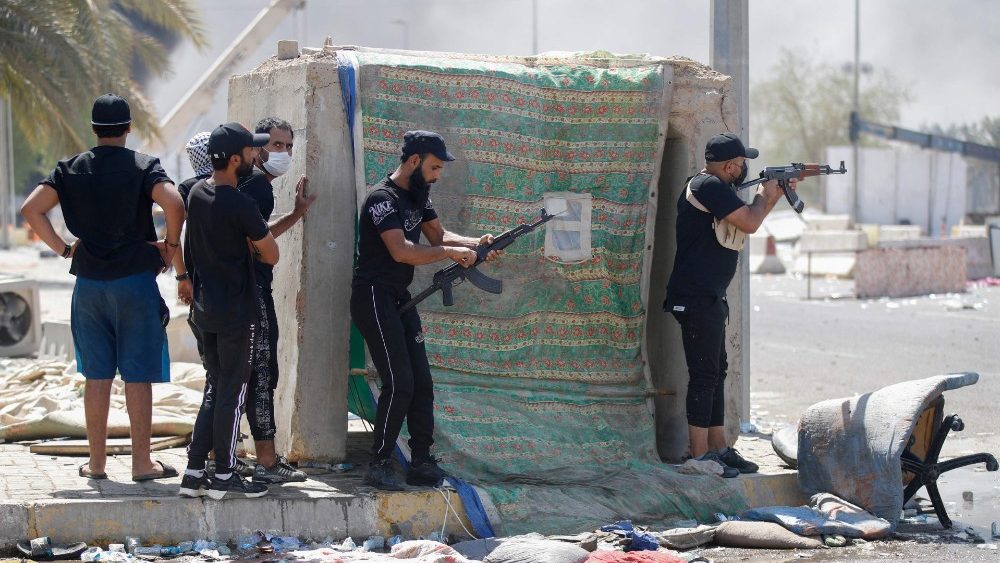 Membros armados da Saraya al-Salam (Brigada da Paz), ala militar afiliada ao clérigo xiita Moqtada al-Sadr, são fotografados durante confrontos com forças de segurança iraquianas na Zona Verde de Bagdá em 30 de agosto de 2022. (Photo by Ahmad Al-rubaye / AFP)