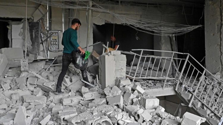 Moradores locais carregam seus pertences de um prédio parcialmente destruído por um ataque de mísseis em Kharkiv em 12 de setembro de 2022, em meio à invasão russa da Ucrânia. (Foto de SERGEY BOBOK/AFP)