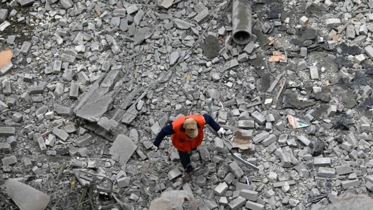 Um trabalhador comunitário caminha pelos escombros de um prédio residencial danificado após um bombardeio em Kharkiv em 21 de setembro de 2022, em meio à invasão russa da Ucrânia. (Foto de SERGEY BOBOK/AFP)