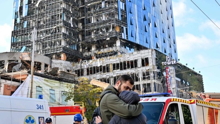 Pessoas reagem do lado de fora de um prédio de escritórios de vários andares parcialmente destruído depois que vários ataques russos atingiram a capital ucraniana de Kyiv em 10 de outubro de 2022, em meio à invasão da Ucrânia pela Rússia. - O chefe das forças armadas ucranianas disse que as forças russas lançaram pelo menos 75 mísseis contra a Ucrânia na manhã de segunda-feira, com ataques fatais contra a capital Kyiv e cidades no sul e oeste. (Foto de Sergei SUPINSKY/AFP)