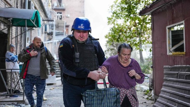 Esta foto divulgada pelo Serviço de Emergência do Estado Ucraniano em 10 de outubro de 2022 mostra um socorrista ajudando uma mulher após ataques na capital ucraniana de Kyiv, em meio à invasão da Ucrânia pela Rússia. (Photo by State Emergency Service of Ukraine / AFP)