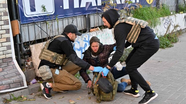 Paramédicos ajudam um morador local após um ataque de drone em Kyiv em 17 de outubro de 2022, em meio à invasão russa da Ucrânia. - Autoridades da Ucrânia disseram em 17 de outubro de 2022 que a capital Kyiv foi atingida quatro vezes em um ataque russo de manhã cedo com drones iranianos que danificaram um prédio residencial e atingiram a estação ferroviária central. (Foto de Sergei SUPINSKY/AFP)