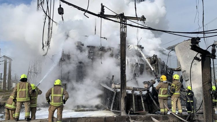 Esta foto divulgada em 22 de outubro de 2022 pelo canal Telegram do chefe da Administração Estatal Regional de Rivne, Vitaliy Koval, mostra bombeiros ucranianos extinguindo um incêndio em uma infraestrutura de energia danificada por um ataque de mísseis na região de Rivne. (Vitaliy Koval Telegram Channel / AFP)