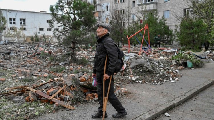 Um homem fica em uma rua após um ataque com foguete em Mykolaiv em 23 de outubro de 2022 durante a invasão russa da Ucrânia. (Foto de BULENT KILIC/AFP)