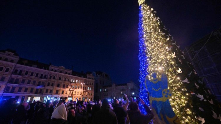 Pessoas tiram selfies durante a cerimônia de inauguração da principal árvore de Natal de Kiev na Praça Santa Sofia, na capital ucraniana de Kyiv, em 19 de dezembro de 2022. - Drones atacaram a capital ucraniana na manhã de 19 de dezembro de 2022, a administração militar da cidade de Kyiv disse, pedindo às pessoas que prestem atenção aos alertas aéreos. (Foto de Sergei SUPINSKY / AFP)