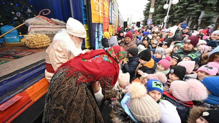 Unos niños ante el "Tren de San Nicolás" en el andén de la estación de ferrocarril de la ciudad de Izyum