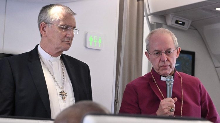 Abp Welby podczas konferencji prasowej na pokładzie samolotu