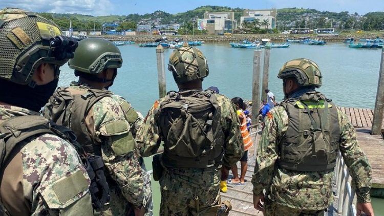 Ecuadorean Navy guard a port where nine people were killed